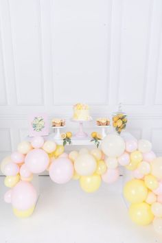 a table topped with lots of balloons and cake