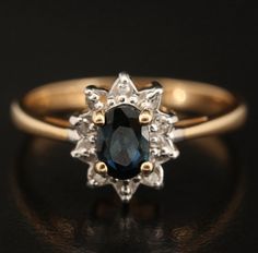 an antique sapphire and diamond cluster ring in yellow gold, with diamonds surrounding the band