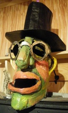 a mask with goggles and a hat on top of a shelf in a room