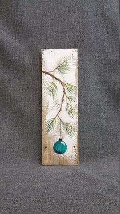 a piece of wood with a green ornament hanging from it