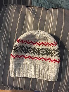 a knitted hat sitting on top of a pillow