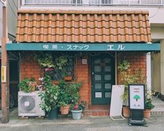 an outside view of a building with plants on the front and in pots next to it