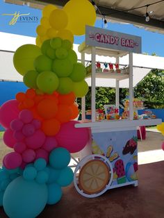 there is a candy bar with balloons in the shape of animals on it and an ice cream stand