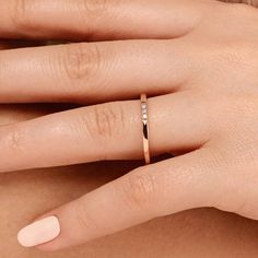 a woman's hand with a diamond ring on her left finger and the other hand holding an engagement ring