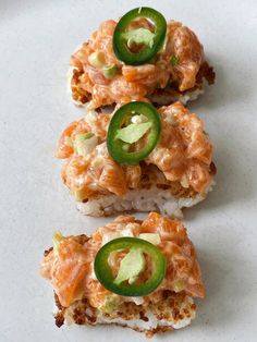 three pieces of sushi with jalapenos on top