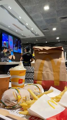 mcdonald's fast food and drinks on a table in a restaurant with people eating