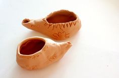 two clay shoes sitting on top of a white table