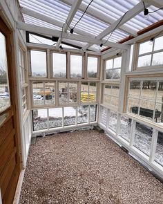 an empty room with lots of windows on the wall and floor, covered in snow