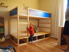 a toddler standing in front of a bunk bed