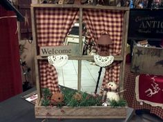 a welcome sign is displayed in front of a window decorated with plaid curtains and teddy bears