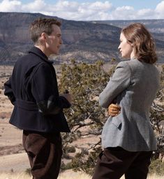 two people standing next to each other in the desert