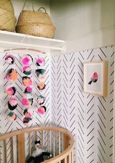 a baby's room with a crib, wallpaper and pictures on the walls