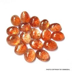 some orange glass beads on a white surface