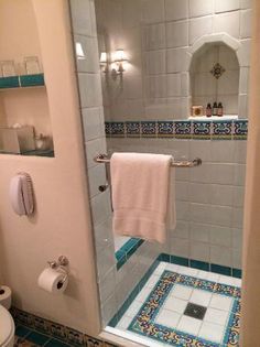 a bathroom with blue and white tiles on the walls