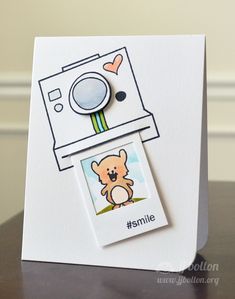 a close up of a small card with a polaroid camera on it's side