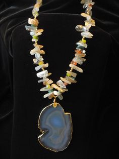 "Beautiful sliced agate in a 'ghost like' blue suspended by polished multi colored stones. Necklace is 32\" in length with sliced stone being 2 7/8\"wide by 3 7/8\" long. Adjustable chain to shorten length by 4\".  This is a re-purposed piece. Necklace is interspersed with gold beads and agate slice has gold rim on edge." St Michael Necklace, Stamped Necklaces, Stones Necklace, Gold Bead Bracelets, Colored Stones, Agate Slice, Agate Necklace, Religious Jewelry, Beaded Necklaces