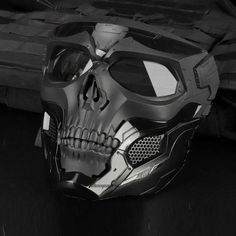 a black and white photo of a helmet with a skull design on it's face