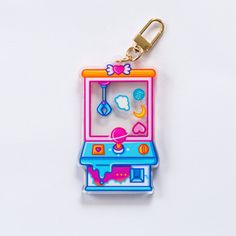 a keychain shaped like an arcade game machine on a white background with clippings