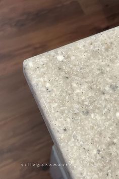 a close up view of a marble table top on a wooden floor with wood grained floors