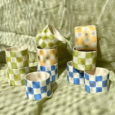 several cups and saucers are sitting on a bed