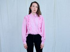 "AUNT GERTRUDE PRESENTS - vintage long sleeve pink shirt - frill at the front - materials: polyester CONDITION (1-10 ❶❷❸❹❺❻❼❽❾ Great condition SIZE/MEASUREMENTS size from label: 44 best fits: XL/XXL shoulder to shoulder: 16 inches (40 cm) bust: 44 inches (112 cm) length: 27 inches (68 cm) sleeve length from armpit: 18,5 inches (47 cm) The model is 5'9\" (174 cm), measures 35-27-38 (90-69-96 cm) and wears size M" Pink Retro Blouse For Fall, Feminine Long Sleeve Ruffled Tops, Pink Retro Fall Blouse, Feminine Long Sleeve Ruffle Tops, Vintage Pink Shirt, Pink Long Sleeve Retro Top, Pink Ruffled Blouse For Fall, Vintage Ruffled Tops For Spring, Spring Vintage Ruffled Tops