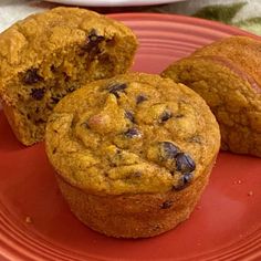 three muffins sitting on top of a red plate