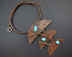 I have cut, shaped, and textured 3 half circles in different sizes. Each one has a bright blue sleeping beauty turquoise stone mounted on the surface. Crescent shapes connect the pieces, creating a sculptural pendant. The copper colored leather cord necklace has handcrafted closure. Lightweight and easy to wear! I have given the copper a warm patina, and finished with a protective polish. Unique Turquoise Copper Necklaces, Unique Turquoise Copper Necklace, Unique Round Pendant Jewelry With Patina, Unique Patina Jewelry With Round Pendant, Leather Cord Necklace, Metalwork Jewelry, Dalmatian Jasper, Leather Corded Necklace, Cabochon Pendant