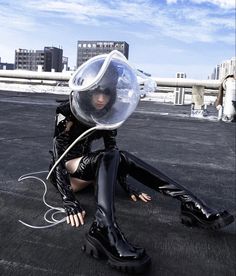 a woman sitting on the ground with a bubble in her head and black leather boots