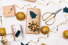 presents wrapped in brown paper with gold ribbon, scissors and other christmas decorations around them