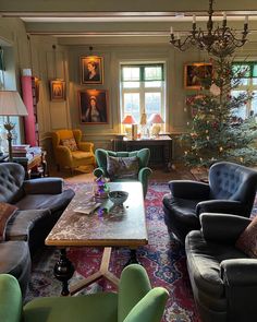 a living room filled with lots of furniture and a christmas tree in the middle of it