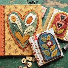 three handmade cards with buttons on them and some scissors in the middle one has an embroidered heart