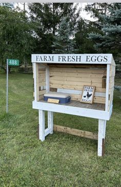 a sign that says farm fresh eggs on it's side in the middle of grass