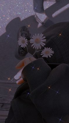 a person holding flowers in their hand and looking at the sky with stars on it