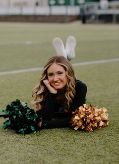 a cheerleader laying on the ground with her pom poms in front of her