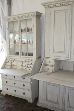 an old white kitchen cabinet with drawers and cupboards next to it on the ground