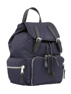 The Burberry Medium 'Rucksack' Backpack, crafted with sustainable nylon and leather trims, measures 14 x 12 x 6 inches. Its navy blue color and sophisticated design make it a statement piece. It features a drawstring fastening, top handle, adjustable shoulder straps, padded back, and multiple pockets for storage. Made in Romania, it is finished with black buckle detailing, silver-toned hardware, and a logo print. Dimensions: 14 x 12 x 6 inches; Color: Navy Blue Sustainable nylon yarn and finishe Burberry Backpack, Rucksack Backpack, Military Inspired, Navy Blue Color, Palm Angels, Burberry Bag, Leather Top, Cloth Bags, Salvatore Ferragamo