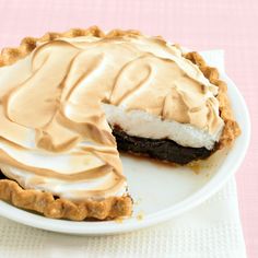 a chocolate pie on a white plate with a slice missing