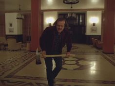 a man is holding a large object in the middle of a room with marble flooring