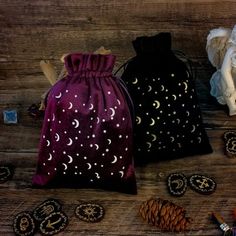 two bags are sitting next to each other on a table with pine cones and buttons