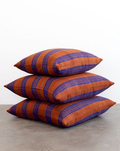 three orange and blue pillows stacked on top of each other