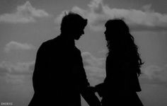 two people standing next to each other in silhouette