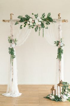 a wedding arch decorated with greenery and flowers