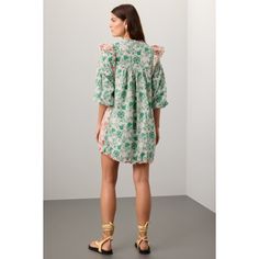 Pink and green cotton (100% Cotton). Shift. Crew neck. Three-quarter sleeves. Front button closure. 35.5" from shoulder to hemline. Imported. 3/4 Sleeve Ruffled Dress For Day Out, Ruffled Dresses With 3/4 Sleeves For Day Out, Day Out Dresses With Ruffles And 3/4 Sleeve, 3/4 Sleeve Dresses With Ruffles For Day Out, Chic Cotton Half Sleeve Dress, Chic Cotton Dress With Half Sleeves, Chic Half Sleeve Cotton Dress, Green Cotton Mini Dress For Vacation, Bohemian Green Dress With Half Sleeves