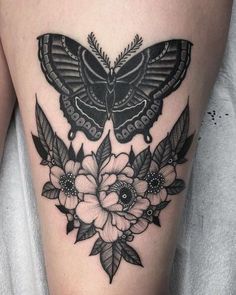 a black and white butterfly with flowers on the thigh