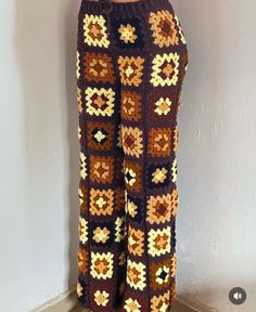 the pants are crocheted and have flowers on them in brown, yellow and white