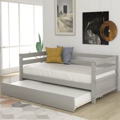 a day bed with trundle and mattress in a white room