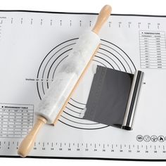 a wooden mallet and ruler sitting on top of a sheet of paper