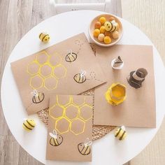 bees and honeycombs cut out from brown paper on top of a white table