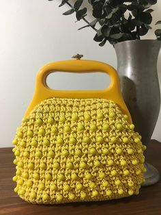 "1960s Yellow Raffia Purse, Vintage 60s Purse, Mid Century Accessory Bright and cheerful yellow raffia purse from the 1960s that features: Yellow plastic faceted beads that cover the entire body of the bag. Heavy plastic handle. Gold tone metal closure that works well and closes tightly. Opens to a yellow fabric lining. There are no loose or missing beads on the exterior.  The heavy plastic handle is a darker shade of yellow but I do believe it was made this way to offset the rest of the bag. Th Vintage Yellow Bags For Spring, Vintage Yellow Bag For Spring, Yellow Vintage Bags, 60s Purse, Mid Century Accessories, Yellow Purses, Raffia Bag, Dark Shades, Yellow Fabric