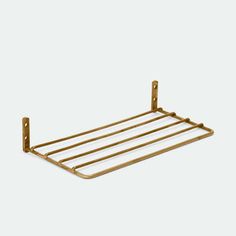 a gold metal shelf with two bars on it and one bar attached to the wall